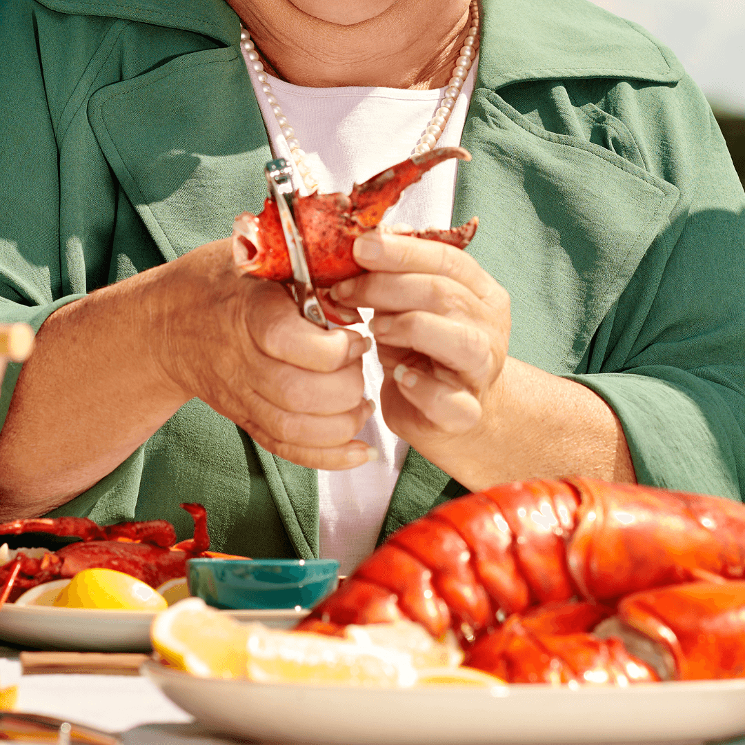 Personne qui décortique une pince de homard