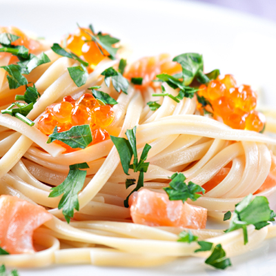 Pâtes crémeuses au basilic garnies de saumon et de caviar