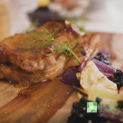 Côtelettes de porc au miel et à l'ail avec légumes rôtis garnis d'un coulis de bleuets