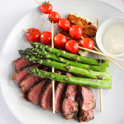 Filet mignon de bœuf grillé et "biftecks" d'halloumi avec brochettes d'asperges et de tomate avec sauce tahini