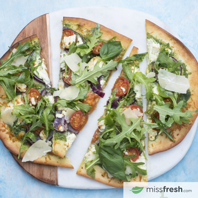 Pizza au fromage de chèvre et pesto avec roquette et parmesan