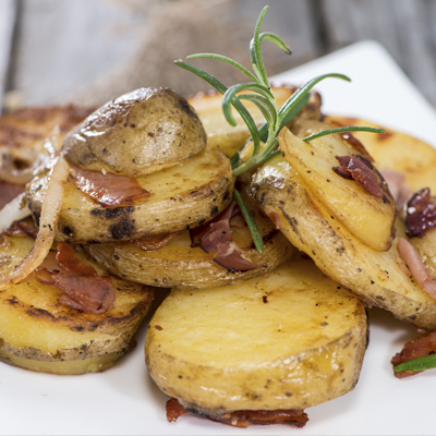 Pommes de terre rôties aux oignons, au romarin et à la pancetta