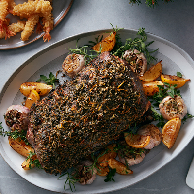 Rôti de bœuf en croûte aux fines herbes et au citron avec citrons et ail rôtis