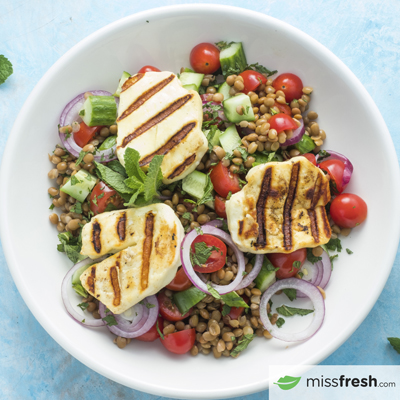 Salade de lentilles et halloumi grillé servie avec pains pita