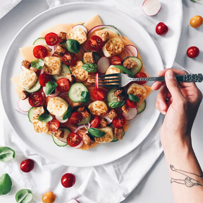 Salade de melon, tomates, concombre, radis, halloumi grillé et croûtons fumés