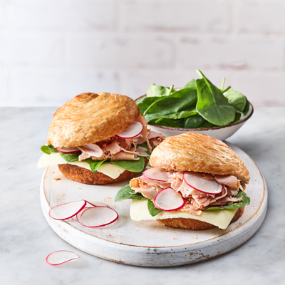 Sandwich poitrine de dinde, fromage, épinards et radis sur croissant brioché