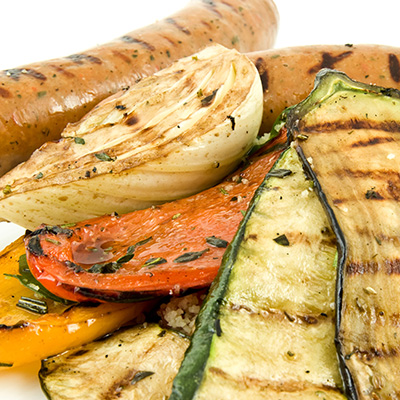 Saucisses européennes et légumes grillés, semoule de blé au concassé de tomates et roquette au BBQ