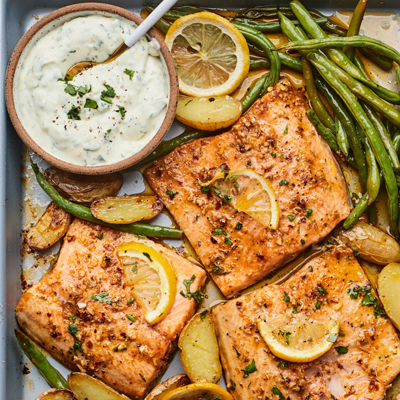 Truite citronnée sur plaque de cuisson, pommes de terre et légumes avec sauce à l'ail et aux fines herbes